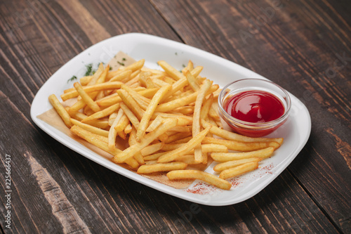 Beer snack - fried potatoes with ketchup on a white plate