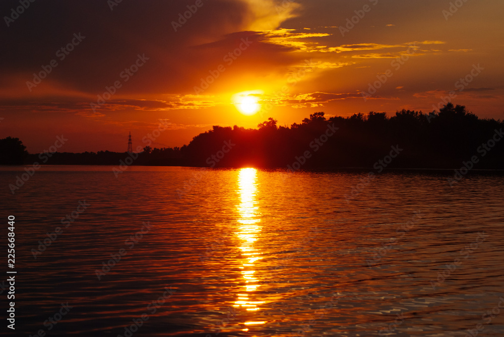 The sun is reflected on the waves, warm summer evening, romantic landscape, bright sunset on the river,
