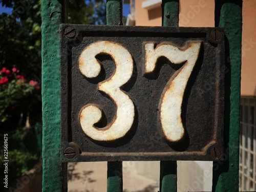 Vintage grunge square metal rusty plate of number of street address photo