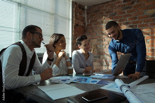 Executives discussing over laptop in conference room