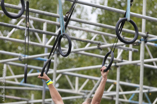 A person on hanging rings during an adventure obstacle course race