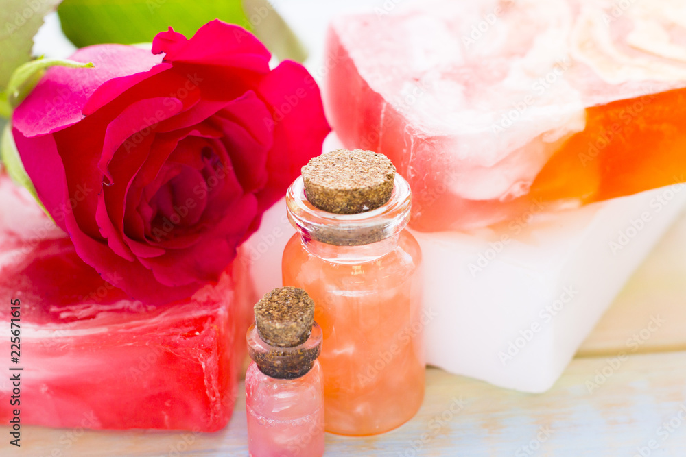 Spa and wellness setting with rose flower, sea salt, oil in a bottle on wooden white background Spa and wellness setting with rose flower, sea salt, oil in a bottle on wooden white background