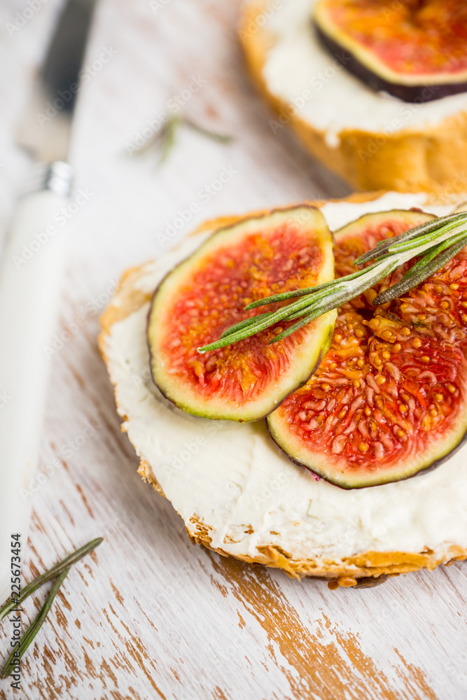 Bread with ricotta cheese, figs and honey on the wooden background. Shallow depth of field. Bread with ricotta cheese, figs and honey on the wooden background. Shallow depth of field.