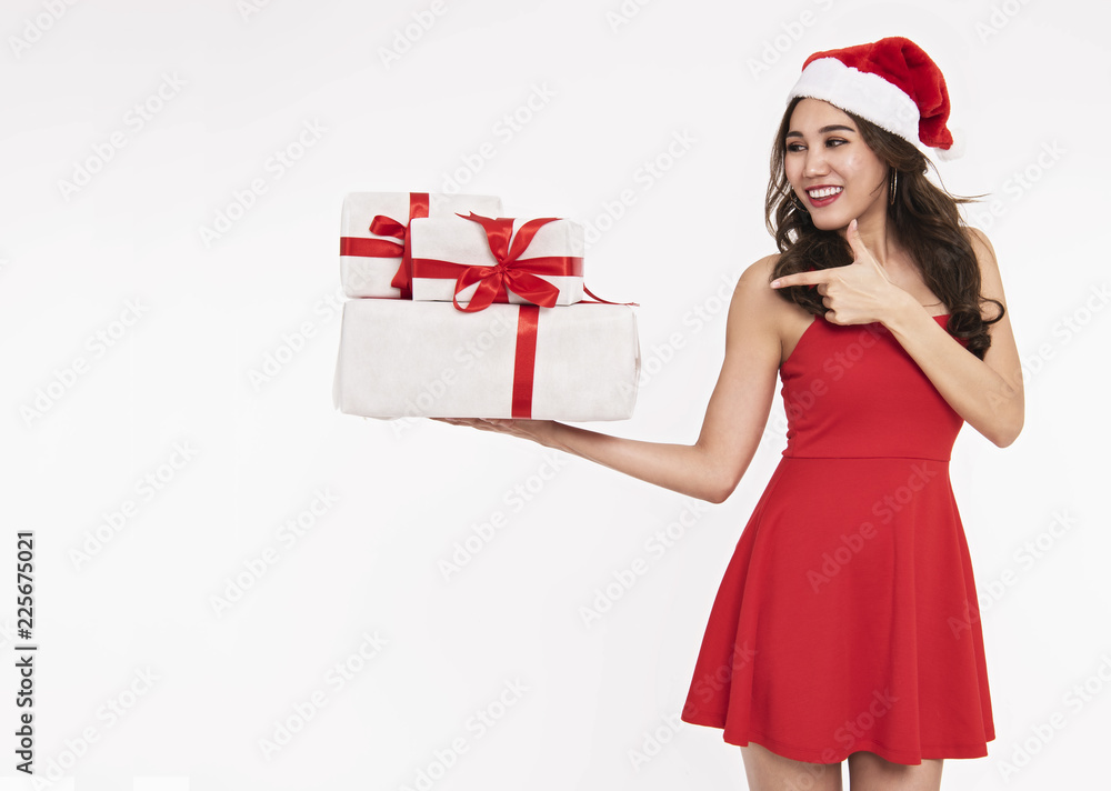 Cheerful young woman in red dress santa holding gift box for christmas isolated on white background. Cheerful young woman in red dress santa holding gift box for christmas isolated on white background.
