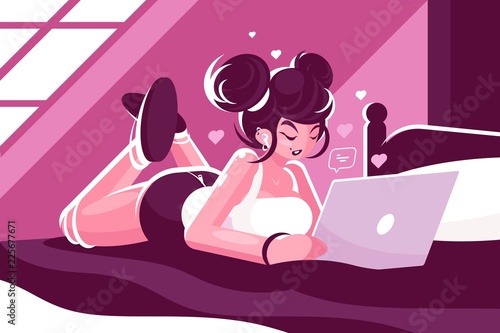 Woman lies on bed and using laptop