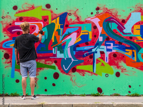 young man use his talent and feeling for art to apply this with various colors to a city wall