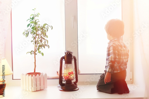 A child in the new year looks out the window. Children are waiti photo