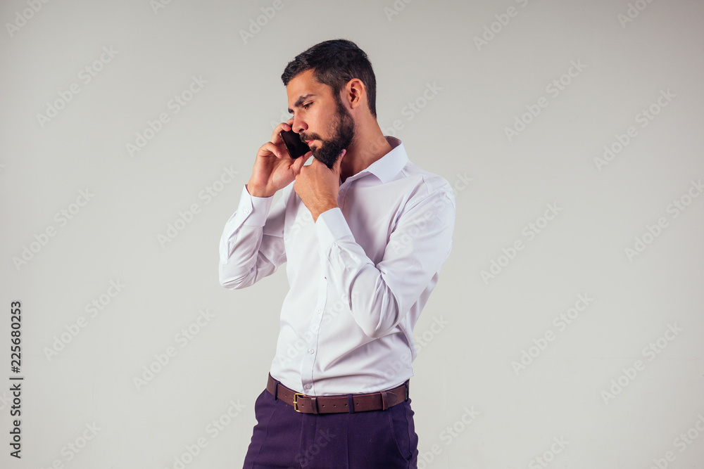 Businessman barber shop owner using mobile phone . Young caucasian bearded man holding smartphone for business work. Businessman barber shop owner using mobile phone . Young caucasian bearded man holding smartphone for business work.