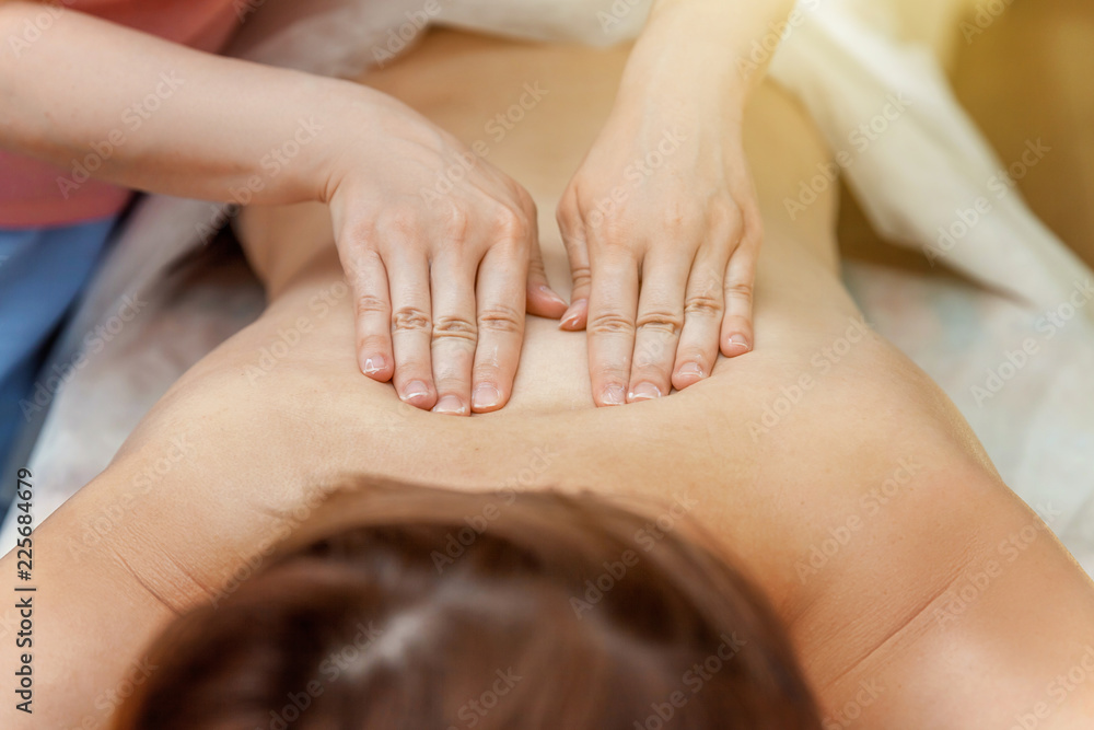 Close-up of young beauty brunette woman getting body back massage treatment in spa salon. Spa skin and body care. Skincare cleansing cosmetic health spa relax pleasure concept Close-up of young beauty brunette woman getting body back massage treatment in spa salon. Spa skin and body care. Skincare cleansing cosmetic health spa relax pleasure concept