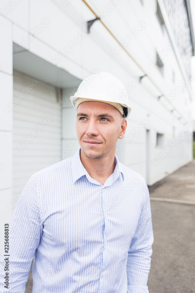 male engineer in helmet on the building background