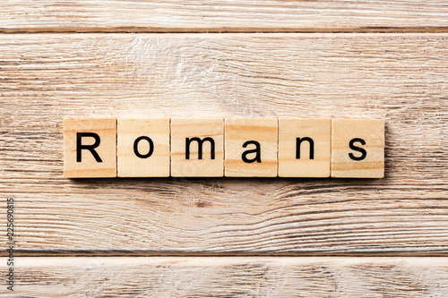 Photography romans word written on wood block. romans text on table, concept