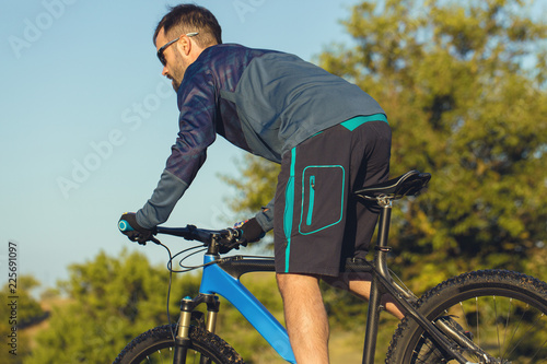 A cyclist rides the hills, Beautiful portrait of a guy on a blue bicycle © Mountains Hunter