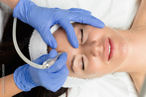 Beautiful woman getting facial microdermabrasion peeling treatment at luxury cosmetic beauty spa clinic. Exfoliation, rejuvenation and hydratation. Cosmetology concept. photo
