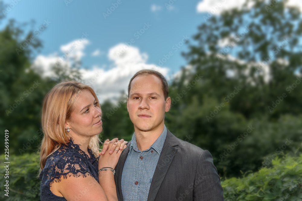 A young couple, man and woman, standing outdoors and looking happy. Concept: love and happiness or family