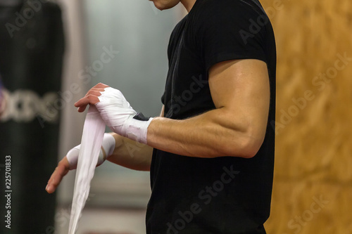 Boxer athlete wears hand protection in training in the gym photo