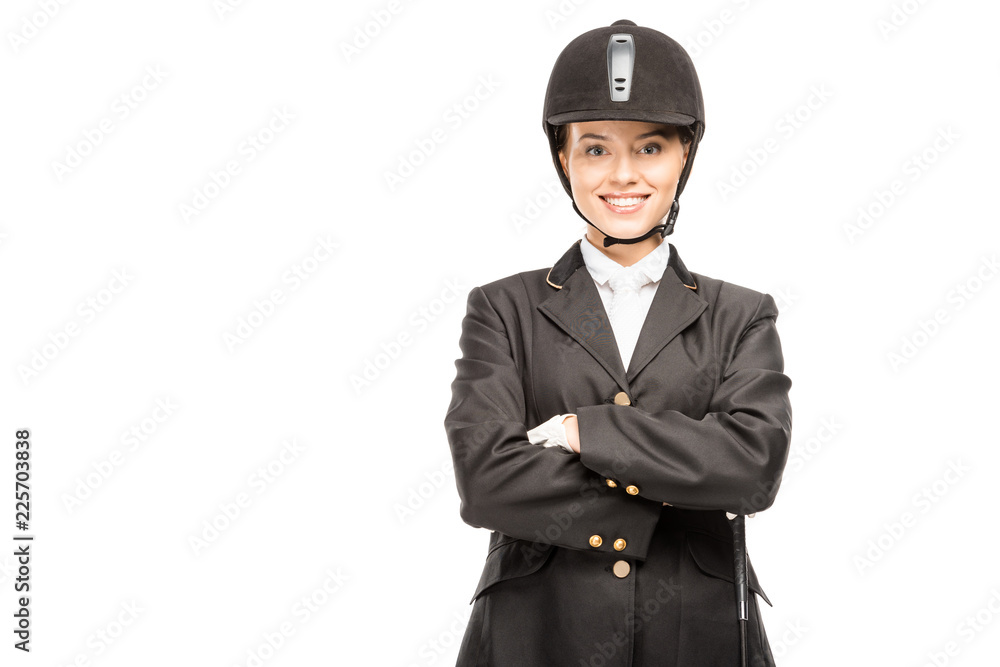 happy young horsewoman in uniform and helmet looking at camera with crossed arms isolated on white happy young horsewoman in uniform and helmet looking at camera with crossed arms isolated on white