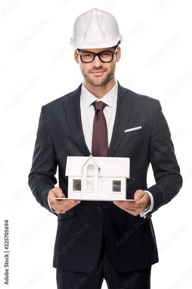 confident young male architect in hard hat showing miniature house isolated on white confident young male architect in hard hat showing miniature house isolated on white