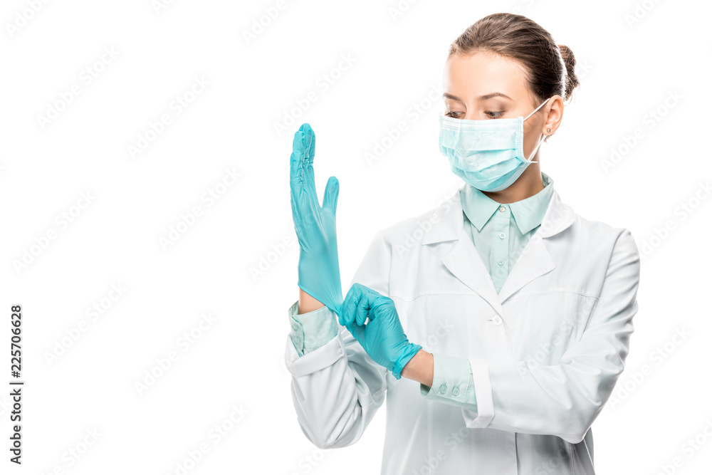 young female doctor in medical mask putting on latex gloves isolated on white young female doctor in medical mask putting on latex gloves isolated on white