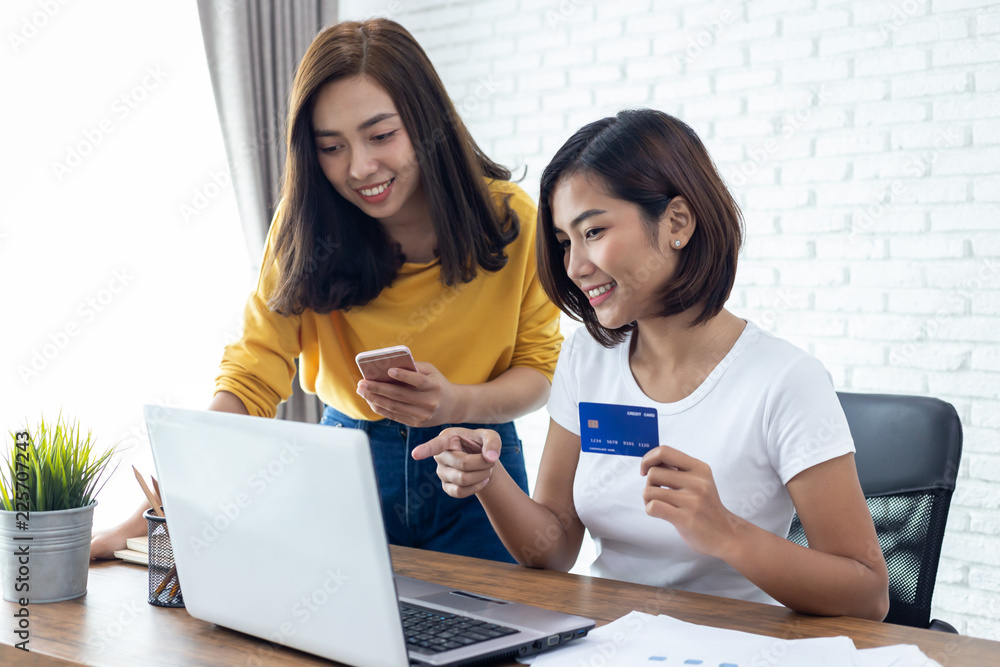 shopping online concept.two young woman holding credit card and mobile smart phone shopping online concept.two young woman holding credit card and mobile smart phone