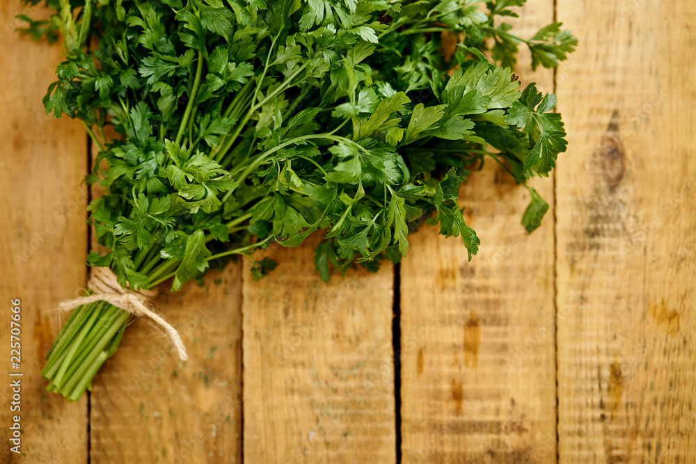 bunch of fresh green parsley on an old wooden kitchen table bunch of fresh green parsley on an old wooden kitchen table