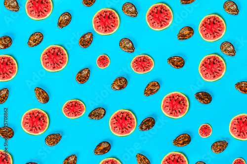 Pattern food background from the pulp of watermelon on a round slice , view from above closeup, the texture of the food against the background of colored paper 