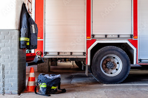 A fire station with a fire truck, jacket and trousers prepared for clothes