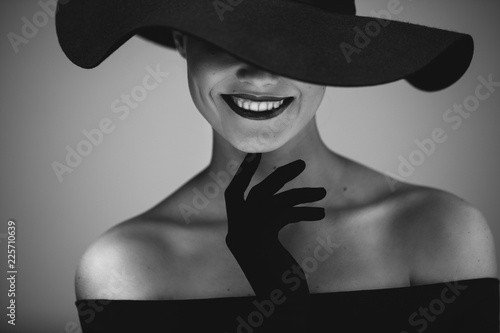 Elegant beautiful woman in a black dress and hat