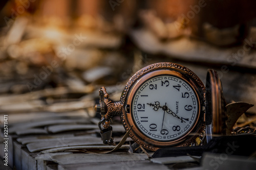 Old pocket watch against an old Piano