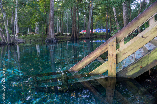 Profile of a wooden staircase coming down in the water od Ginnie Springs  Florida. Cypress forest in the lagoon