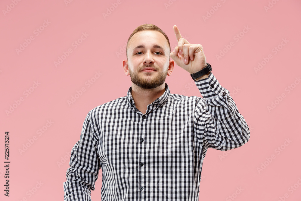 Fototapeta premium Happy businessman pointing up on pink studio background. Beautiful male half-length portrait. The human emotions, facial expression concept.