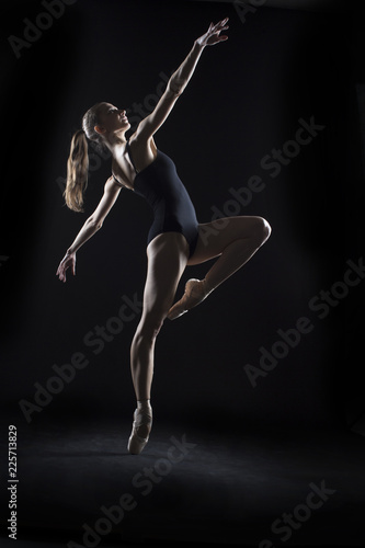 In the photo studio a young ballerina with a beautiful body dances.