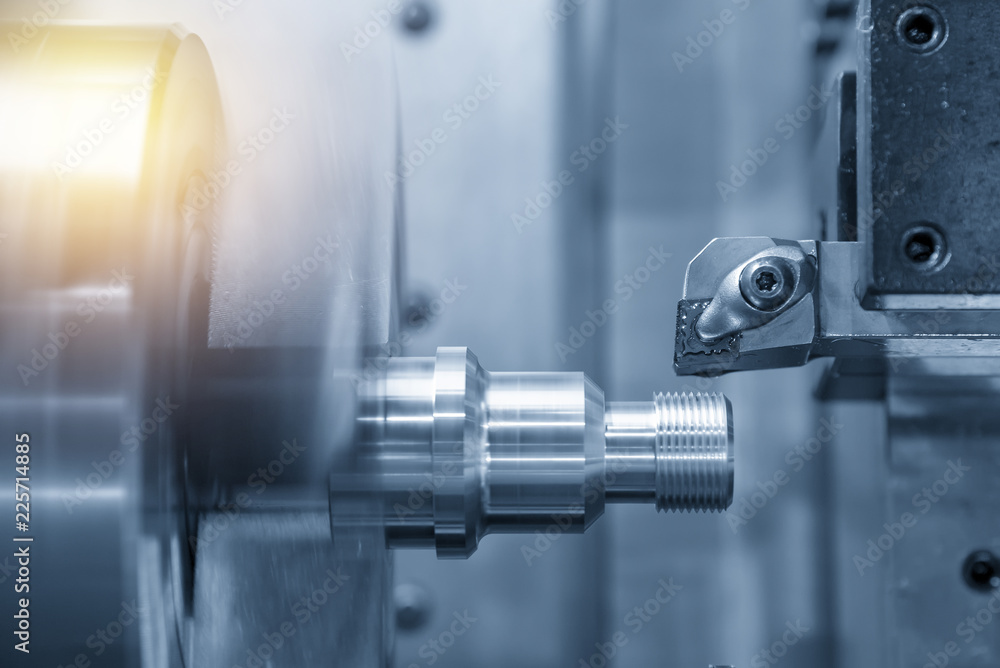 The CNC lathe or turning machine cutting the thread at the metal shaft.Hi-technology manufacturing process. The CNC lathe or turning machine cutting the thread at the metal shaft.Hi-technology manufacturing process.