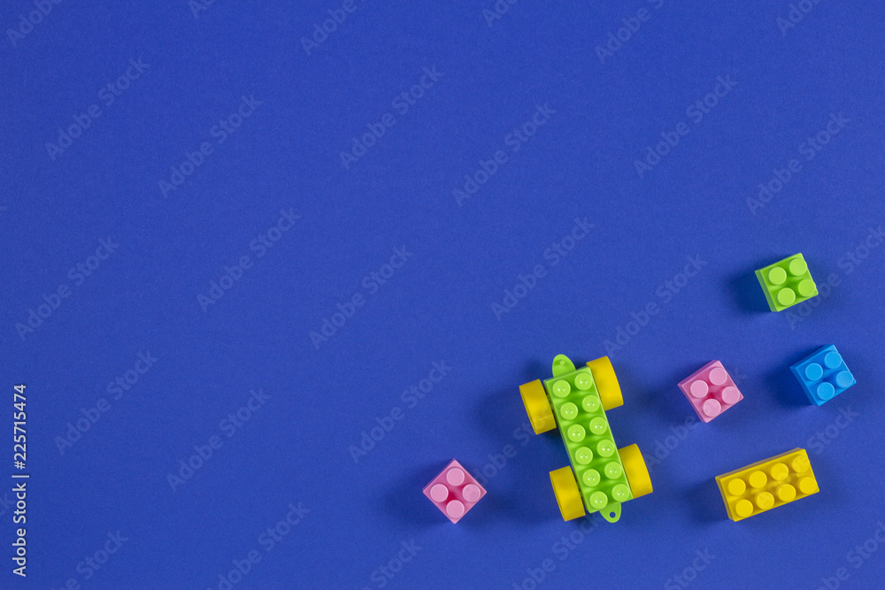 Colorful plastic toy car building blocks on blue background