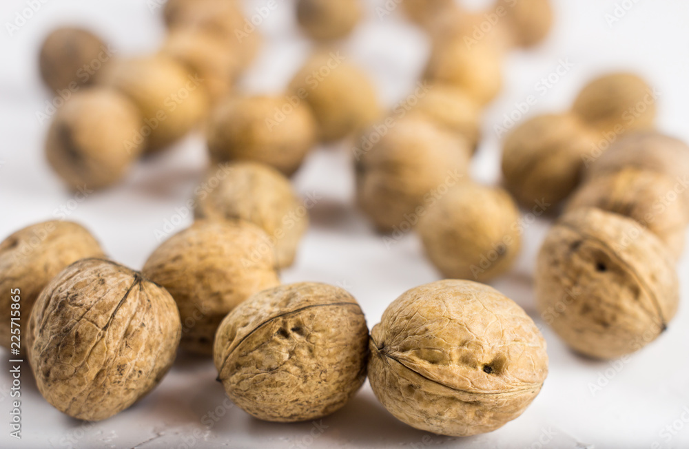 Walnuts on white textured surface. Close up. Walnuts on white textured surface. Close up.