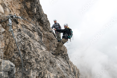 young climbers on a steep and exposed rock face climbing a Via Ferrata