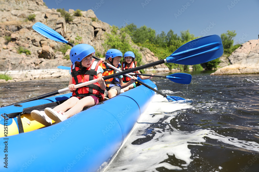 Naklejka premium Little children kayaking on river. Summer camp