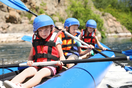 Little children kayaking on river. Summer camp