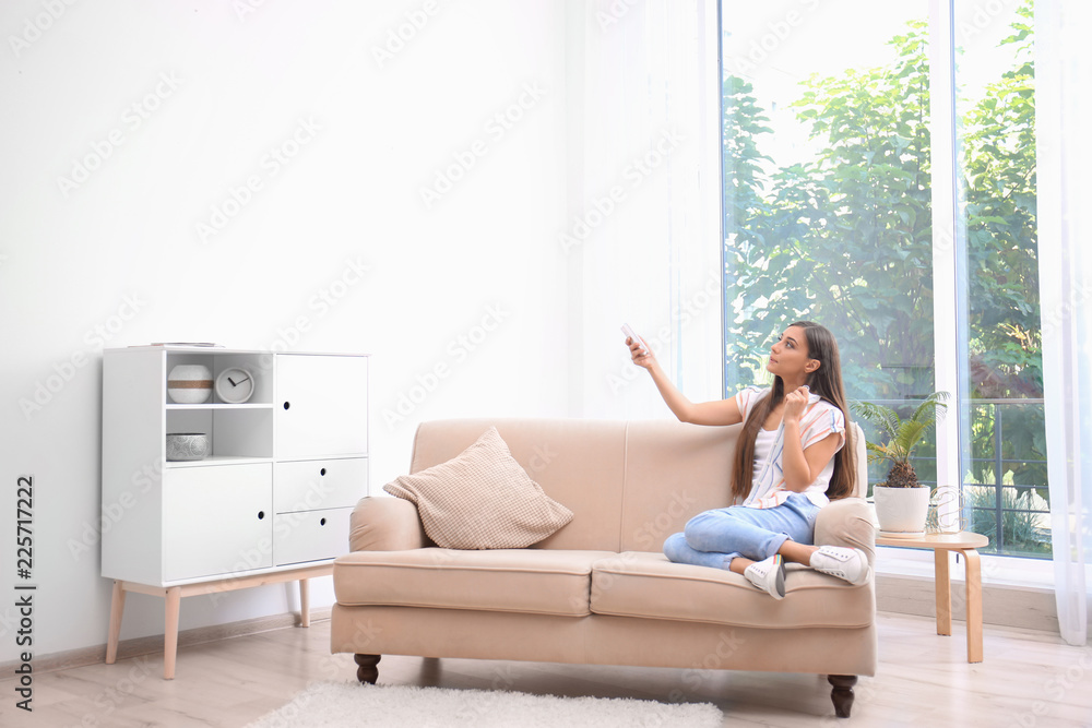 Young woman suffering from heat at home. Air conditioner malfunction Young woman suffering from heat at home. Air conditioner malfunction