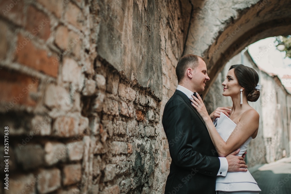 Married couple hugging near old wall Married couple hugging near old wall