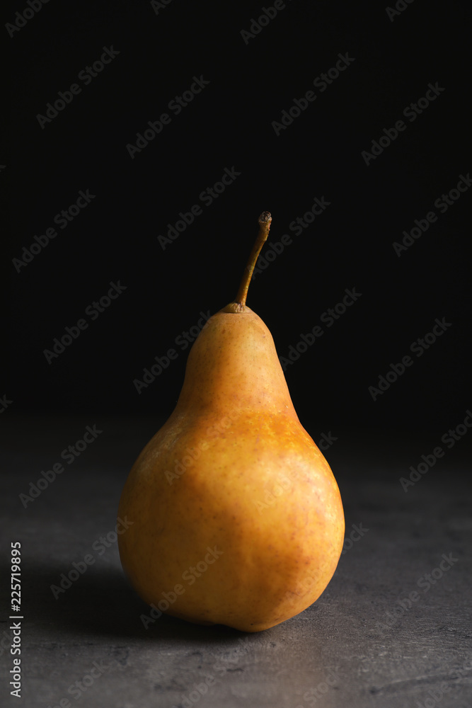 Ripe pear on table against black background. Space for text Ripe pear on table against black background. Space for text