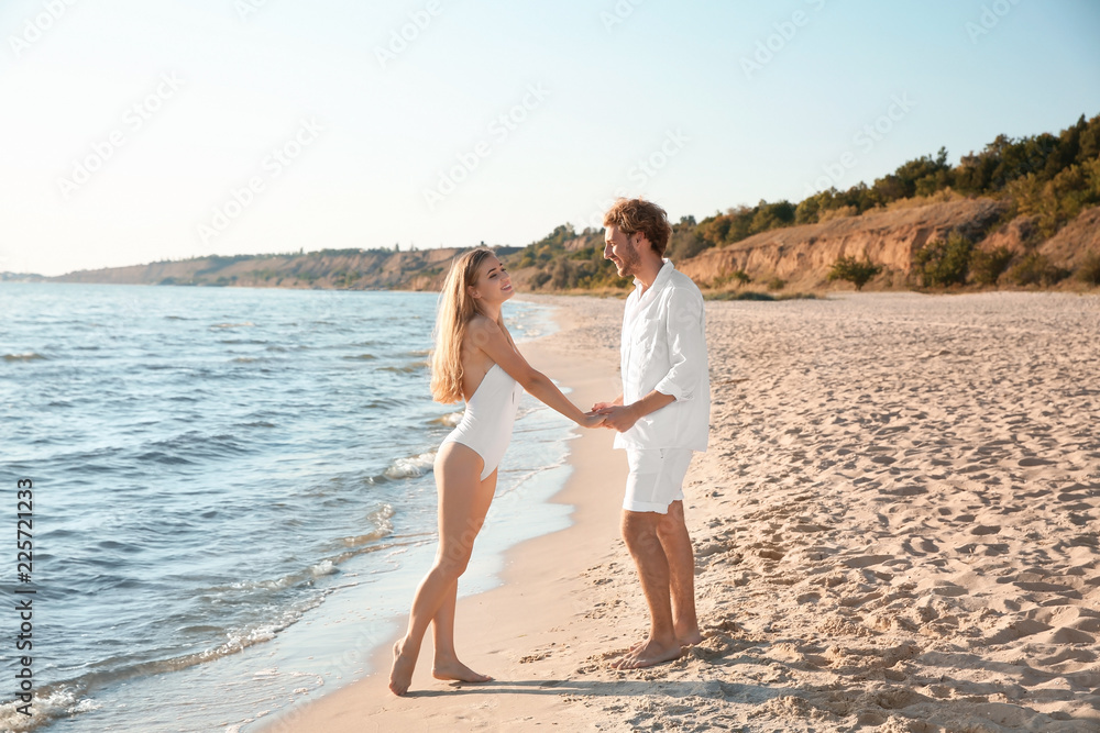 Fototapeta premium Romantic young couple spending time together on beach