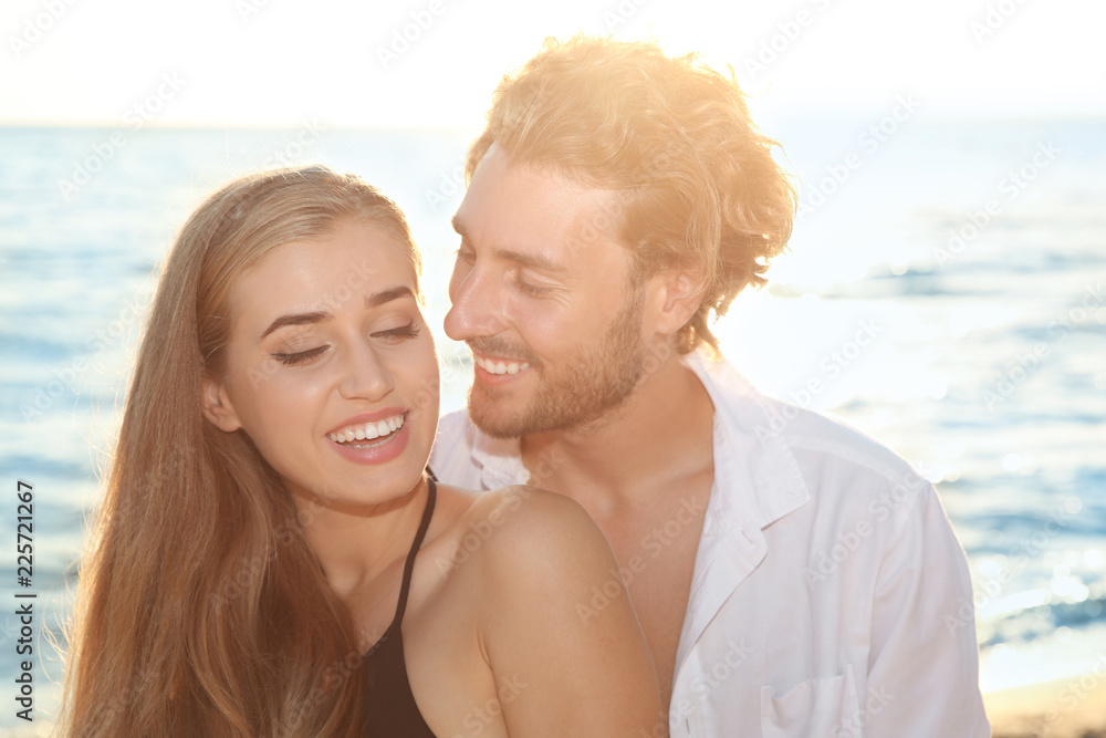 Obraz premium Romantic young couple in beachwear spending time together on seashore