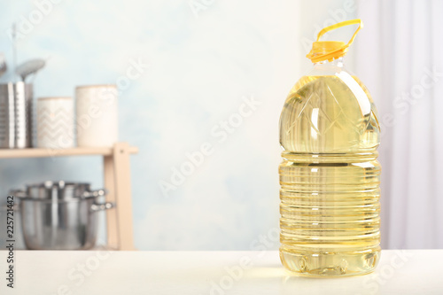 Fototapeta Naklejka Na Ścianę i Meble -  Bottle of oil on table against blurred background. Space for text