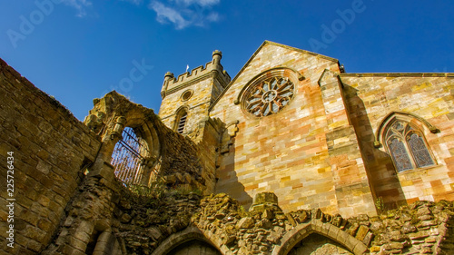 Beautiful stone arched gateway at the ruins of the monastery in Culross with black metal gate.  photo