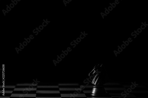Fotografia black horse chess on a chessboard in the dark background