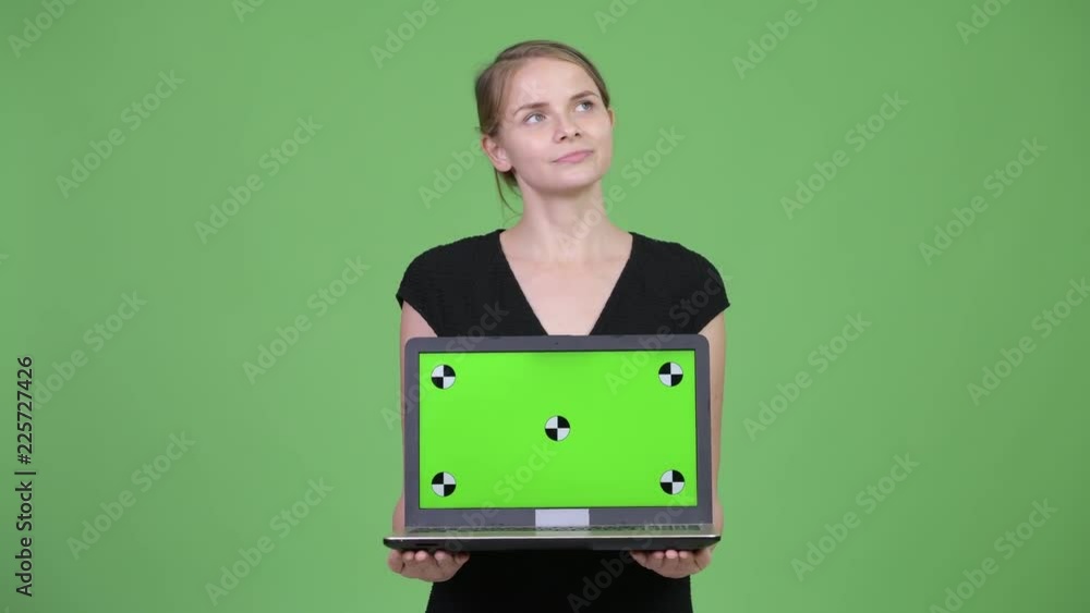 Young happy businesswoman thinking while showing laptop Young happy businesswoman thinking while showing laptop