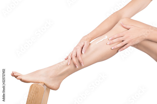 Female hands massage female leg with cream, close up