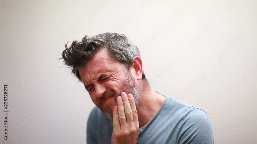 Man holds his hand near the cheek toothache Man holds his hand near the cheek toothache