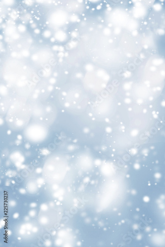Blue Christmas background with frosty snowflakes and glittering bokeh stars. Abstract Glowing blurred lights
