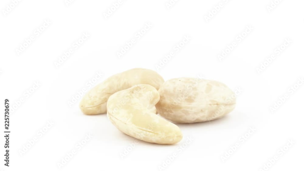 Three raw blanched cashew nuts. Rotating on the turntable isolated on the white background. Close up. Macro. Three raw blanched cashew nuts. Rotating on the turntable isolated on the white background. Close up. Macro.